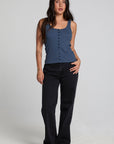 A full body front view of a woman wearing the Chaser Velora Dark Denim Tank on a neutral background with hand on hip
