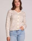 Front view of a woman wearing the Chaser Zebra Dream Striped Cardigan on a neutral background with one hand in pocket