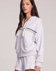 Side angle view of a woman wearing the Chaser Contrast Strappings Zip-Up set on a neutral background