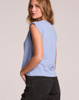 Back view of a woman wearing the Chaser Cropped Cap Sleeve Blue Hydrangea Crewneck Tee on a neutral background