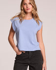 Front view of a woman wearing the Chaser Cropped Cap Sleeve Blue Hydrangea Crewneck Tee and jeans on a neutral background