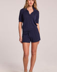 A full body front view of a woman wearing the Chaser Evie Admiral Shorts set on a neutral background