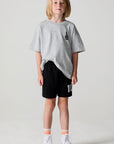 A full body front view of a boy wearing the Chaser Go Team Shorts on a neutral background
