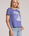 Side angle view of a woman wearing the Chaser Good Times Sailing Club Tee on a neutral background with a hand on her hip