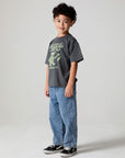 Full body side angle view of a boy wearing the Chaser Grateful Dead Tour Tee on a neutral background