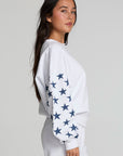 Side view of a woman wearing the Chaser High Spirits Long Sleeve on a neutral background with pants