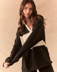 Front view of woman wearing a black and white Chico long sleeve with striped design against a beige background