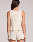 Back view of a woman in a matching tank and shorts set on a neutral background