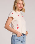 Side view of a woman wearing the white Chaser Lips Embroidery Tee on a neutral background
