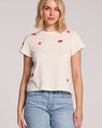 Front view of a woman wearing the Chaser Lips Embroidery Tee and jeans on a neutral background