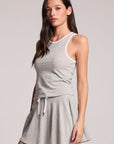 A side angle view of a woman wearing the Chaser Heather Grey Lisbon Tank on a neutral background