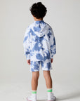 Full body back view of a boy wearing the Chaser Paxton Mistel Tie Dye Zip Up Hoodie on a neutral background