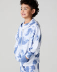 Side angle view of a boy wearing the Chaser Paxton Mistel Tie Dye Zip Up Hoodie on a neutral background