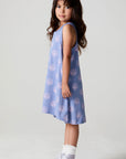 A full body side view of a girl wearing the Chaser Seashell Dreams Allover Dress and sneakers on a neutral background