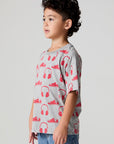 Side angle view of a boy wearing the Chaser Sneaks and Headphones Tee on a neutral background