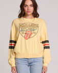 Front view of a woman wearing the Chaser The Rolling Stones 1978 Long Sleeve Tee and jeans on a neutral background with arms lowered