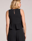 Back view of a woman wearing a black Chaser Liberty tank set on a neutral background