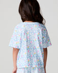 Back view of a girl wearing the Chaser Unicorn Lightning Tee on a neutral background