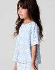 Side angle view of a girl wearing the Chaser Unicorn Lightning Tee on a neutral background