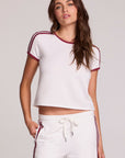 Front view of a woman wearing the Chaser Urban Cloud White Tee and white pants on a neutral background