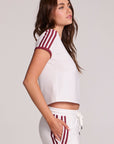 Side view of a woman wearing the Chaser Urban Cloud White Tee and matching pants on a neutral background
