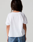 Back view of a girl wearing the Chaser Willie Nelson Cowgirl Tee on a neutral background