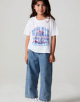 Full body front view of a girl wearing the Chaser Willie Nelson Cowgirl Tee on a neutral background