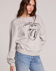 Front view of a woman wearing the Chaser The Rolling Stones Long Sleeve Tee on a neutral background with hand on one hip