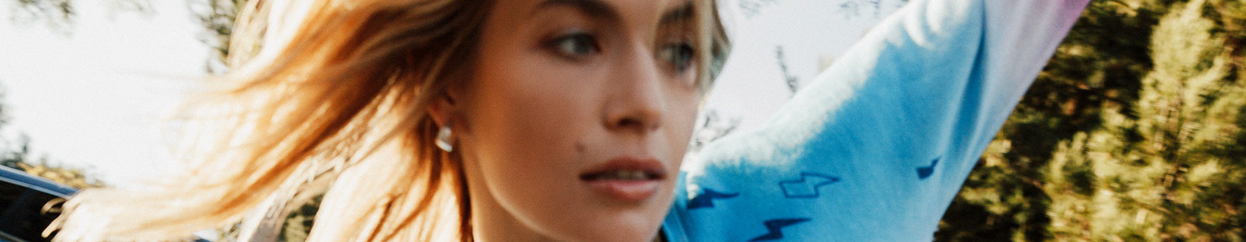 Chaser $25 Edit – women’s tie-dye sweatshirt in motion, outdoor sunlit shot capturing effortless SoCal energy and movement.