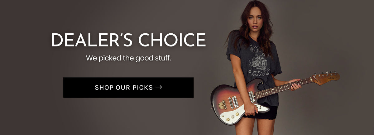 Model wearing Chaser’s SoCal Motorcycles graphic tee and black mini skirt while holding a circa-1965 Japanese Super Astrotone electric guitar