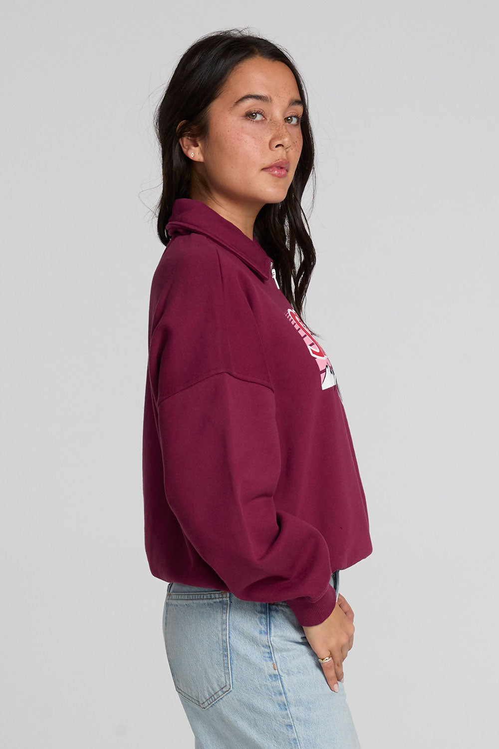 Side view of a woman wearing the Chaser 1986 Ski Club Long Sleeve on a neutral background with pants