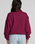 Back view of a woman wearing the Chaser 1986 Ski Club Long Sleeve and jeans on a neutral background