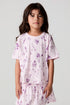 Front view of a girl wearing the Chaser Allover Sweets Tee on a neutral background