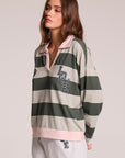 Side angle view of a woman wearing the Chaser Allstar 62  Long Sleeve on a neutral background with hands behind her back