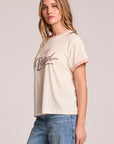 Side angle view of a woman wearing the Chaser  Avec Le Band Tee on a neutral background