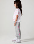 Full body side view of a girl wearing the Chaser  Bolting Bolt Pant on a neutral background
