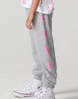Side view of a girl wearing the Chaser  Bolting Bolt Pant on a neutral background