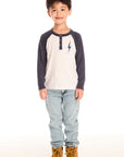 Full body view of boy wearing Chaser’s Lightning Bolt henley long sleeve top with jeans and brown boots on a white background
