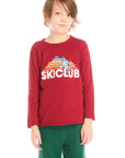 Boy wearing Chaser’s Ski Club red pullover long sleeve with “SKICLUB” text and colorful mountain silhouette graphic on a white background