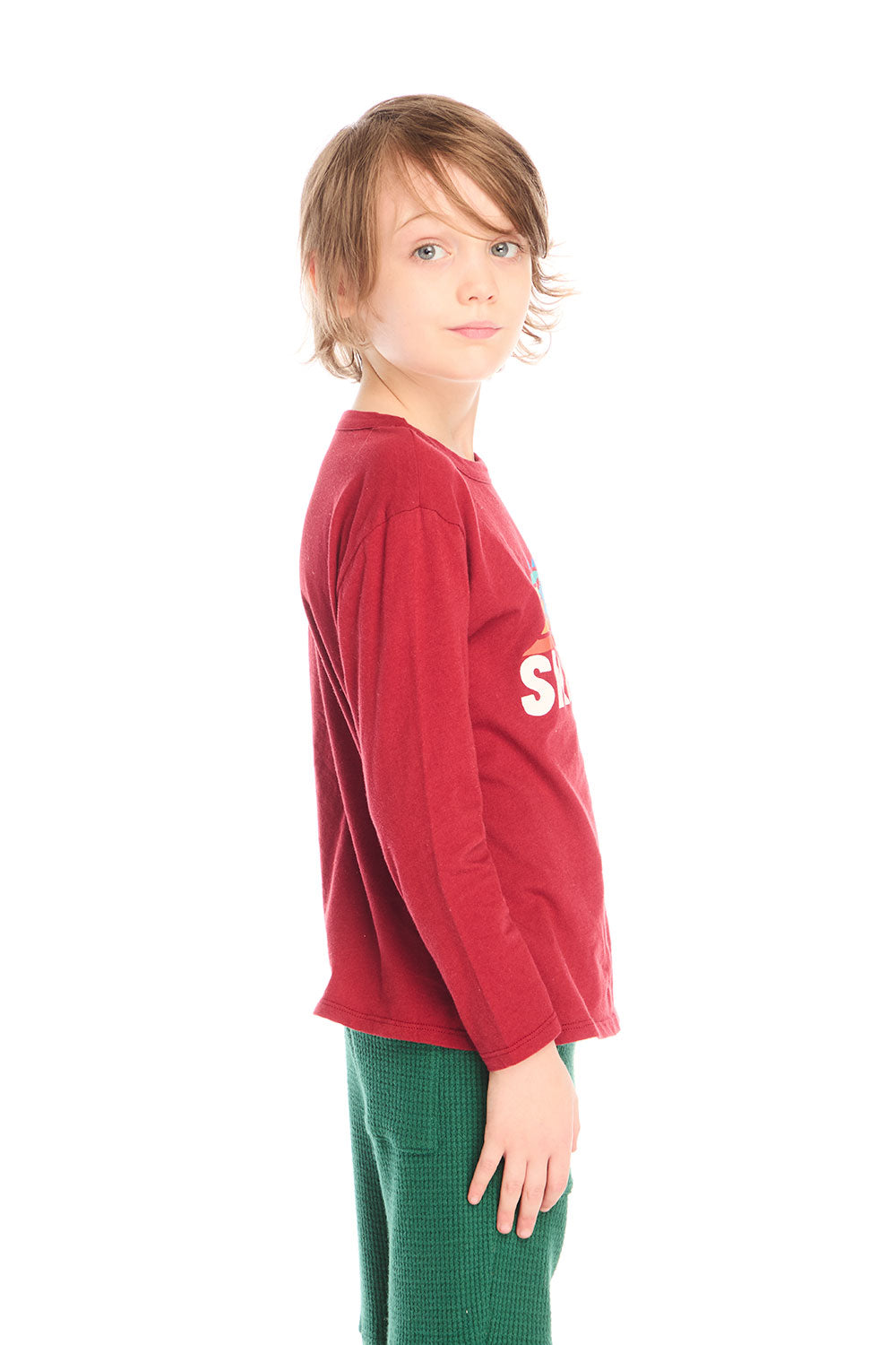 Side view of boy wearing Chaser’s Ski Club red pullover long sleeve with mountain silhouette graphic on a white background