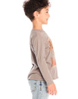 Side view of boy wearing Chaser’s Hold Your Horses dark grey long sleeve with cowboy horse graphic against a white background