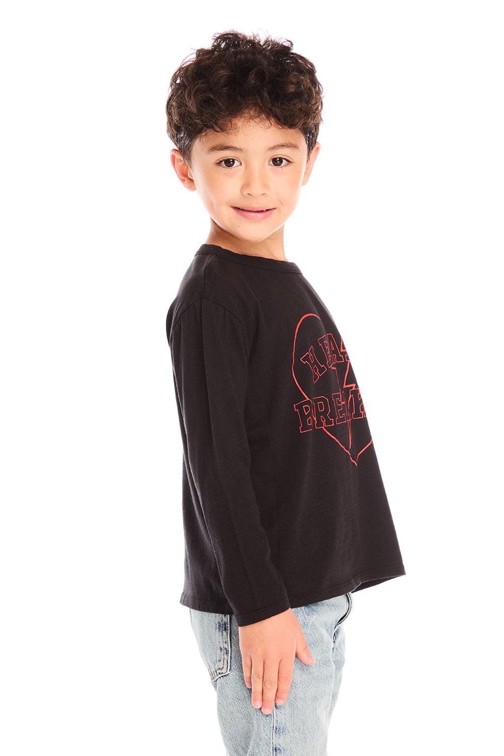 Side view of boy wearing Chaser’s Heartbreaker black long-sleeve shirt with red text and broken heart graphic on a white background