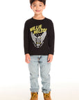 Full body view of boy wearing Chaser’s Willie Nelson Willie 1978 black long sleeve with eagle graphic, light blue jeans, and brown boots on a white background
