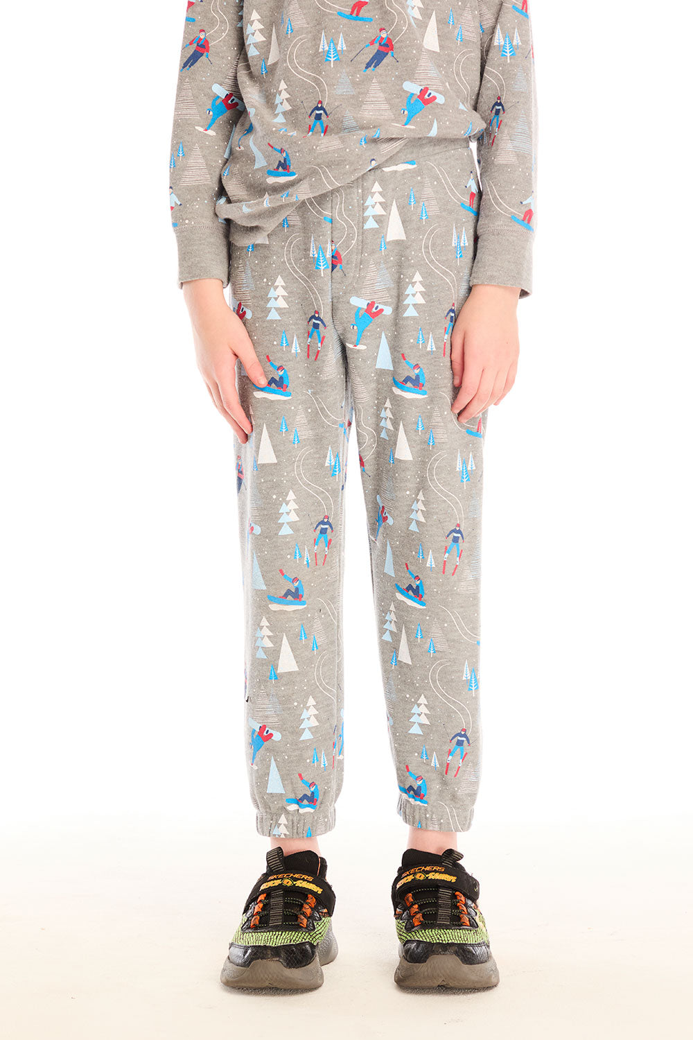 Boy wearing Chaser's gray Allover Ski Slope Pants and matching top with colorful patterns on a white background
