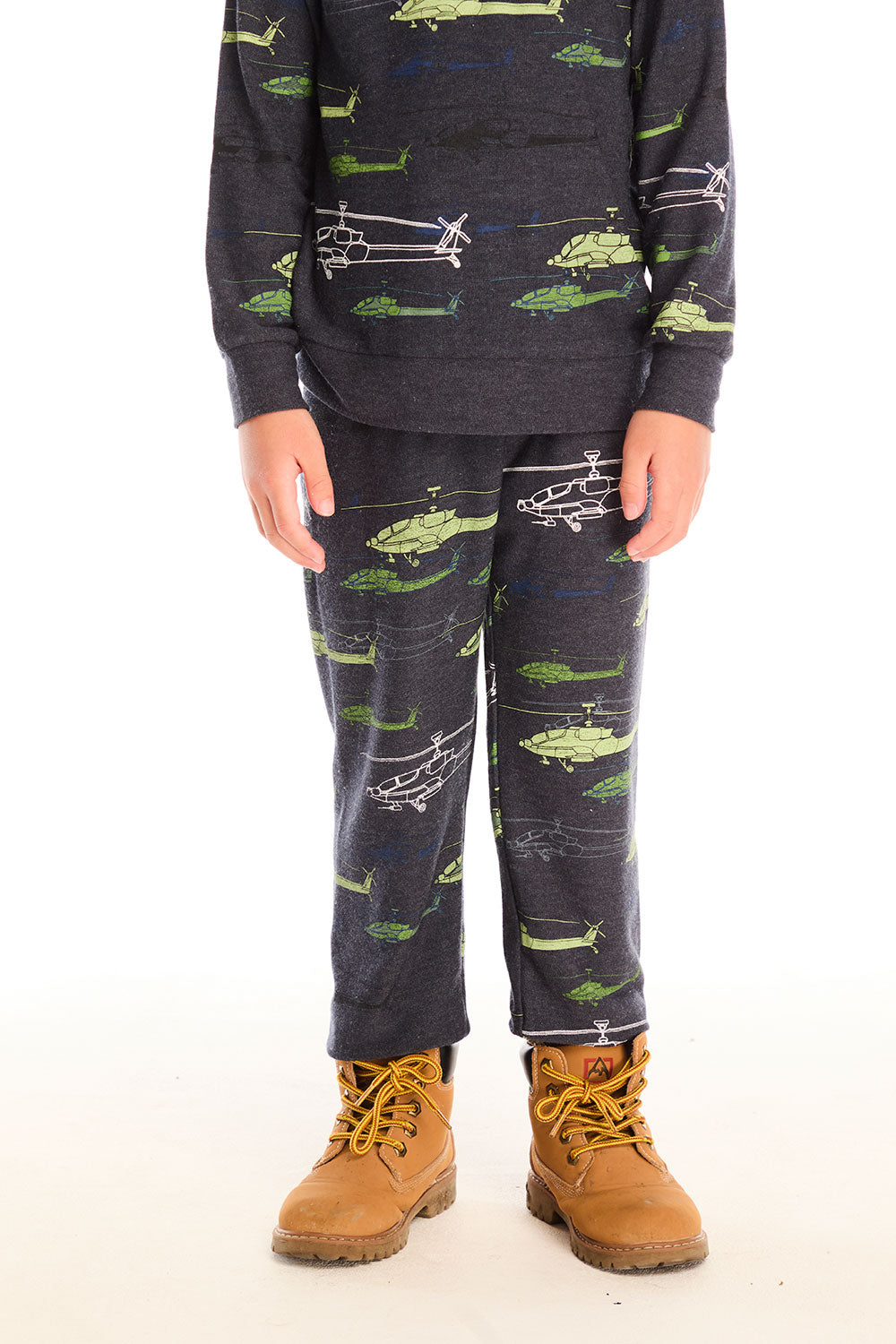 Boy wearing Chaser's dark gray Allover Helicopters pant with green airplane patterns and matching top on a white background
