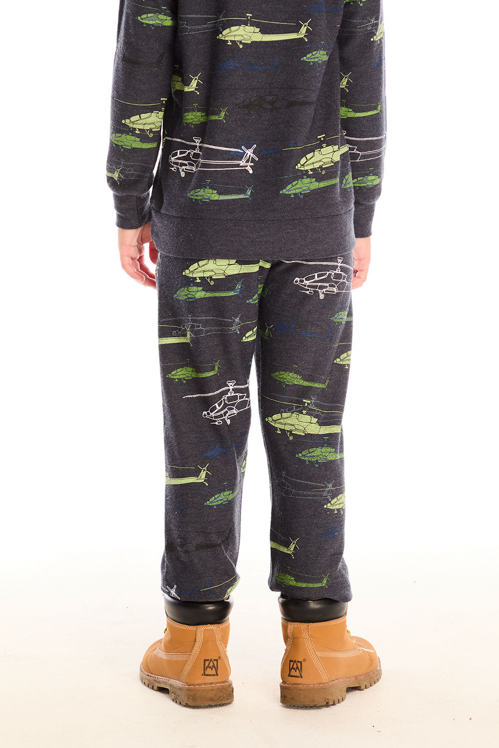 Back view of boy wearing Chaser's dark gray Allover Helicopters pant with green airplane patterns and matching top on a white background