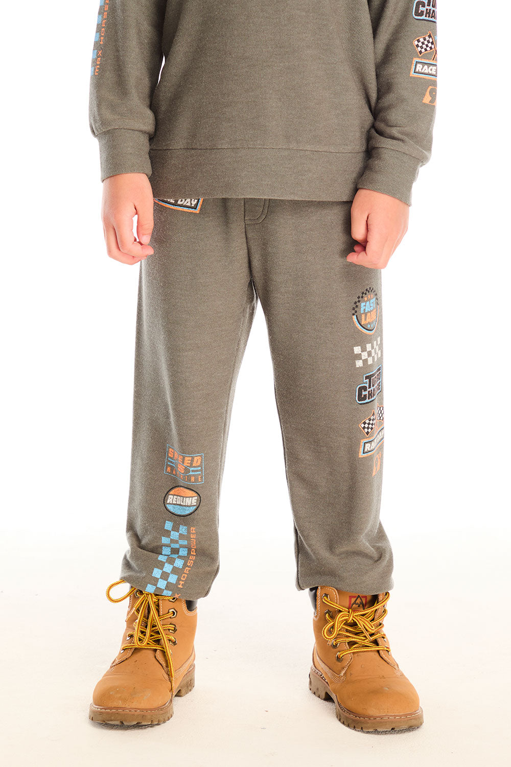 Boy wearing Chaser’s Champion Racing Team pants in safari green with matching long sleeve top on a white background