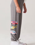 Model wearing Chaser's Heroes Boys Jogger in charcoal with first-responder vehicle graphics, side view
