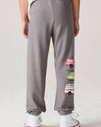 Model wearing Chaser's Heroes Boys Jogger in charcoal with first-responder vehicle graphics, back view