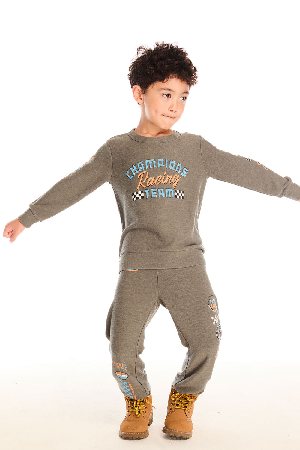 Full body view of boy wearing Chaser’s Safari Green Champions Racing Team long sleeve top with matching pants on a white background